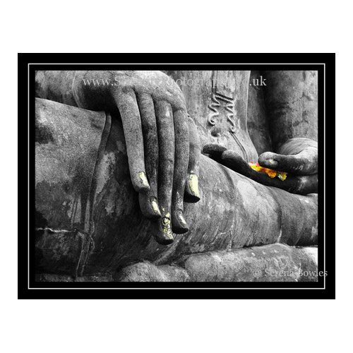Statue of Buddha, with garlands of flowers on the hand. Colour composite. Sukkhothai, Thailand.